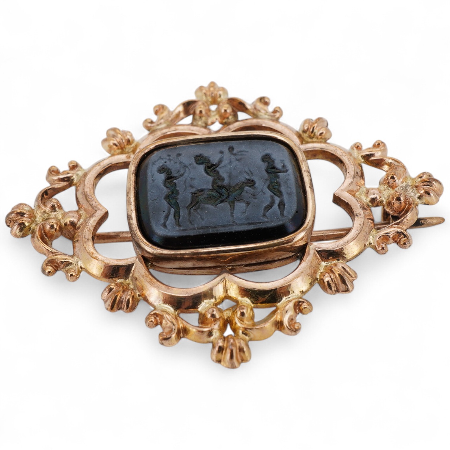 A yellow metal and glass intaglio set brooch, carved with figures, of quatrefoil shape, 43mm.